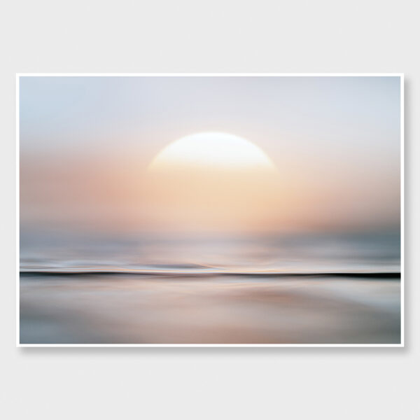 A soft-focus seascape with gentle pastel tones, showing the sun dissolving into a calm horizon.