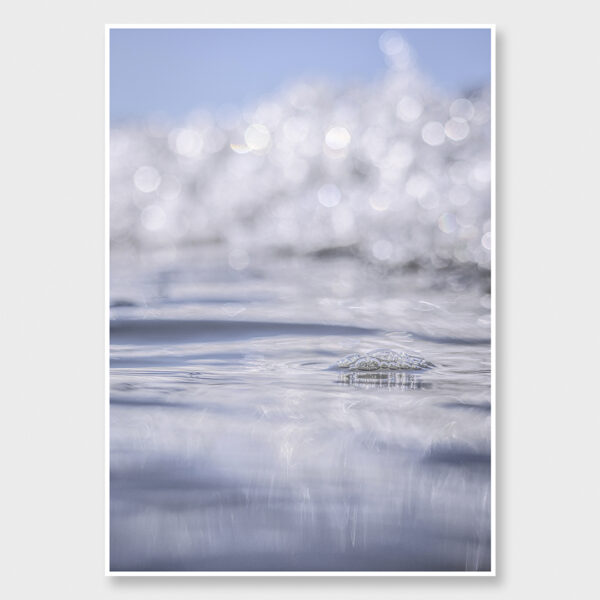 Ethereal fine art seascape photograph with soft summer light reflecting on calm ocean water and a bubble.