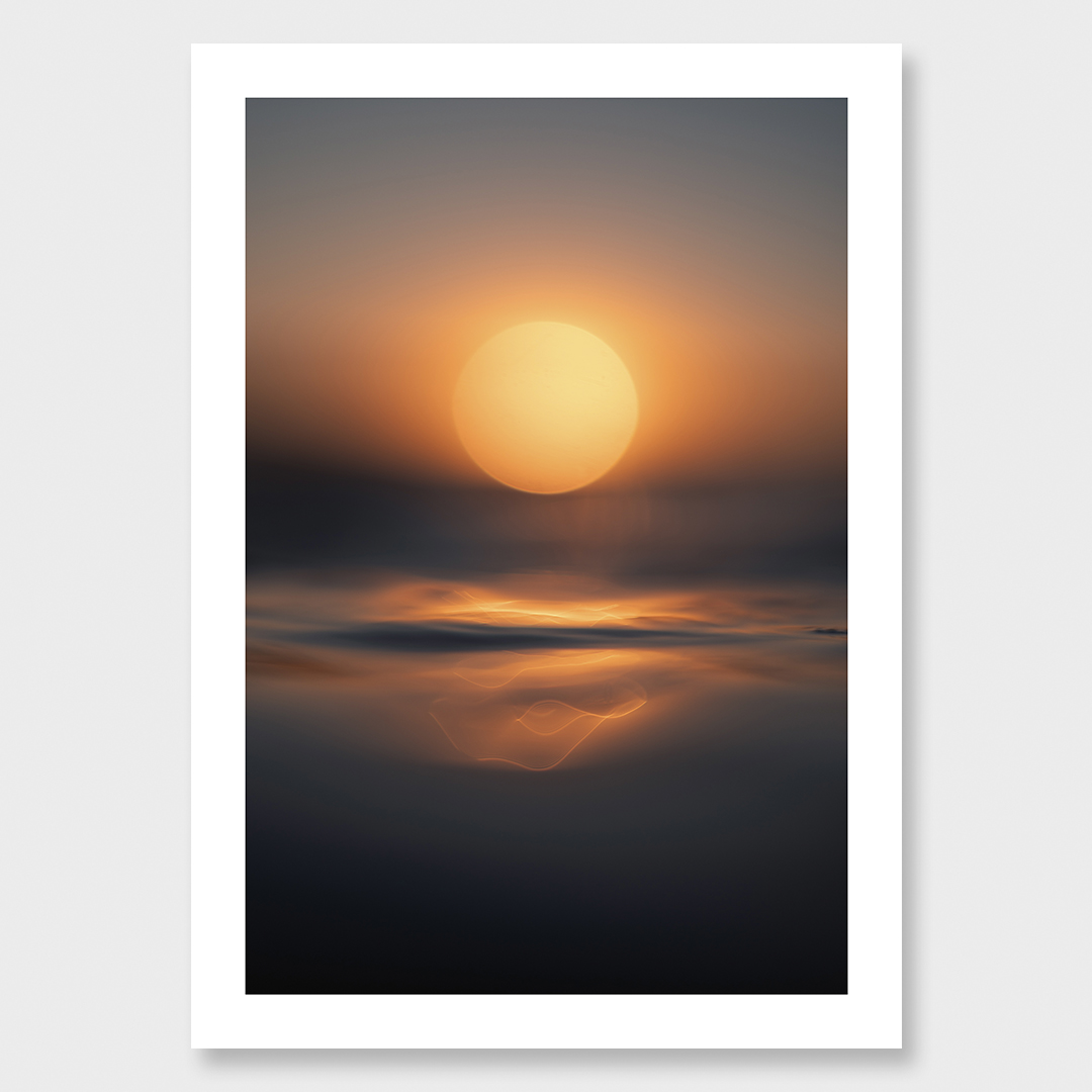 Atmospheric fine art seascape featuring a large glowing sun above calm ocean water, captured from sea level at sunset with soft reflections and warm golden light.